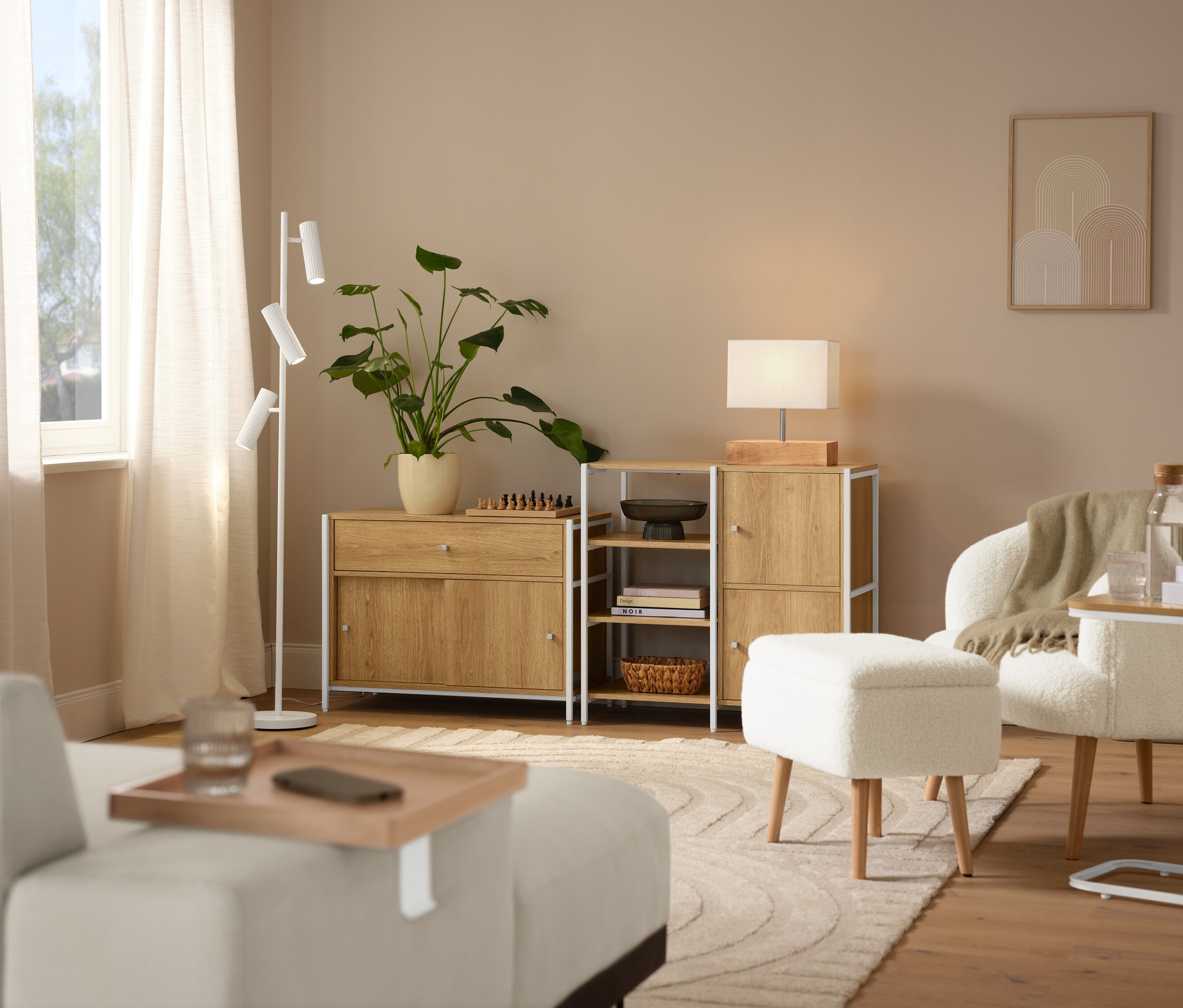 Interiérová scéna s béžovým kobercom »Cosmo«, kreslom z buklé s drevenými nožičkami a stolovou lampou s dreveným podstavcom.