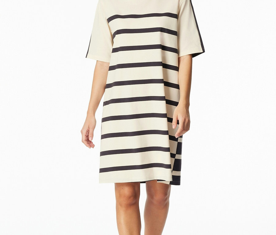 Žena má na sebe béžové a námornícke modré pruhované tričkové šaty s krátkym rukávom po kolená.