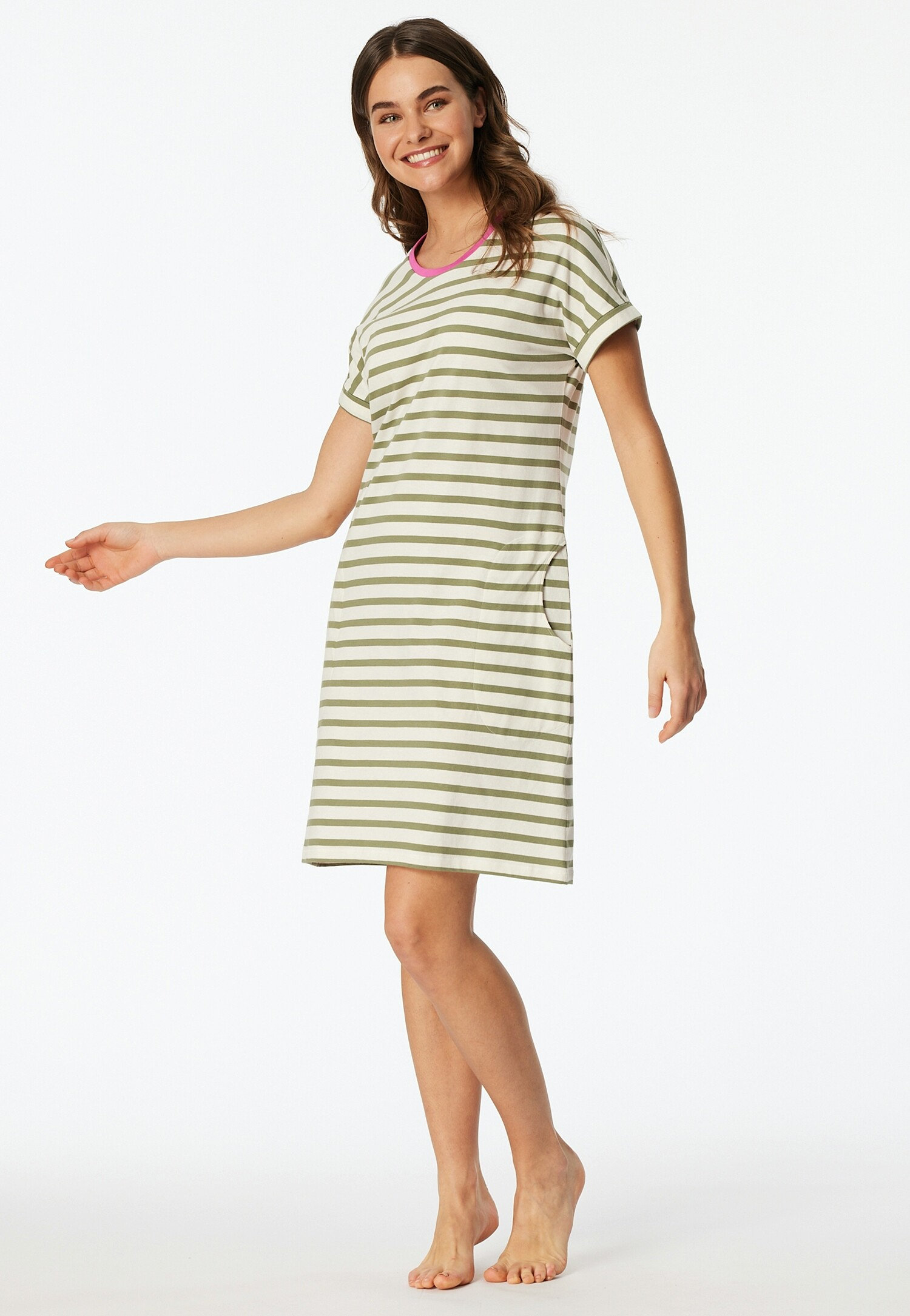 Žena má na sebe pruhované tričkové šaty s ružovými akcentmi na výstrihu.