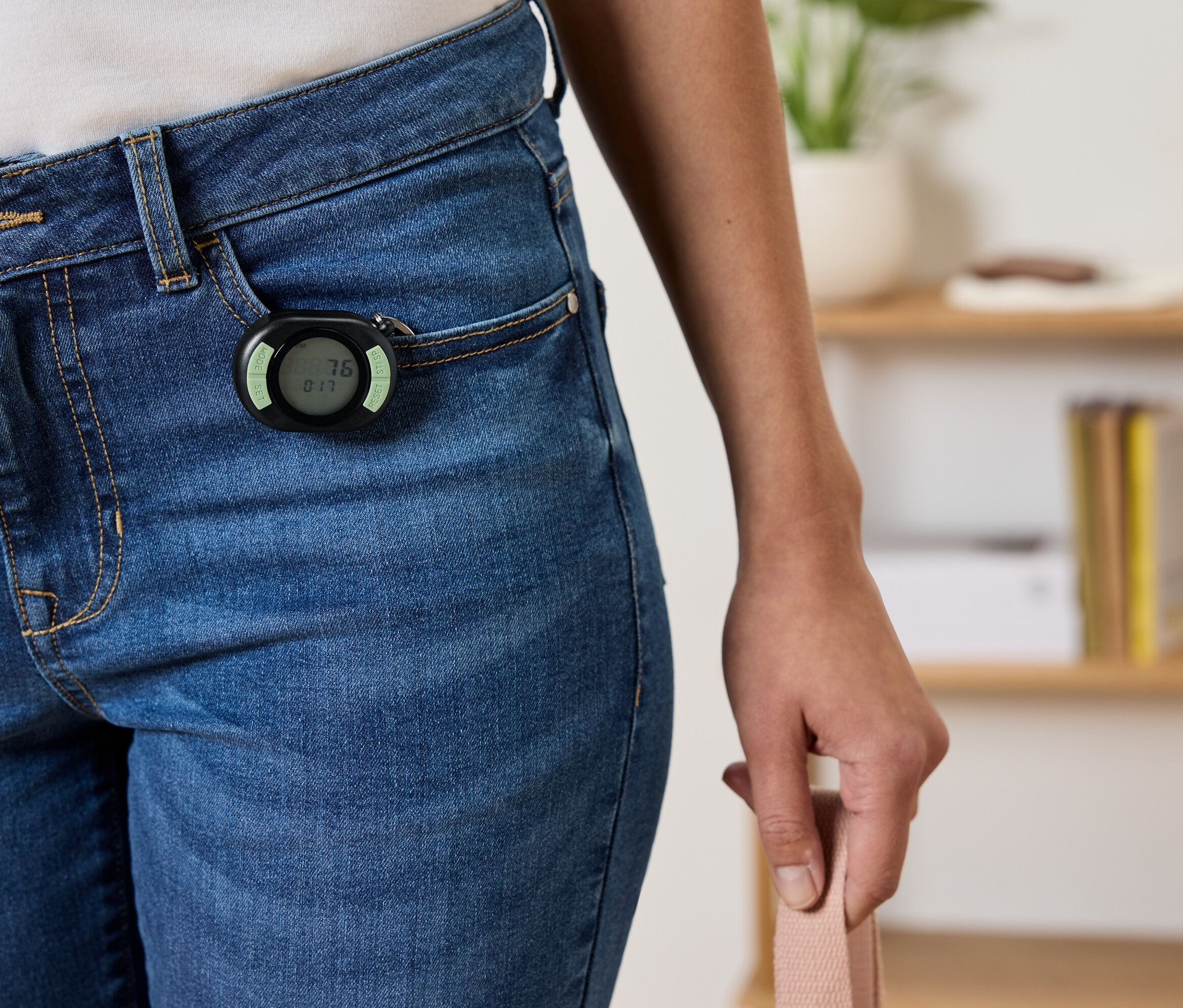 Čierny krokomer pripevnený k prednému vrecku modrých džínsov.