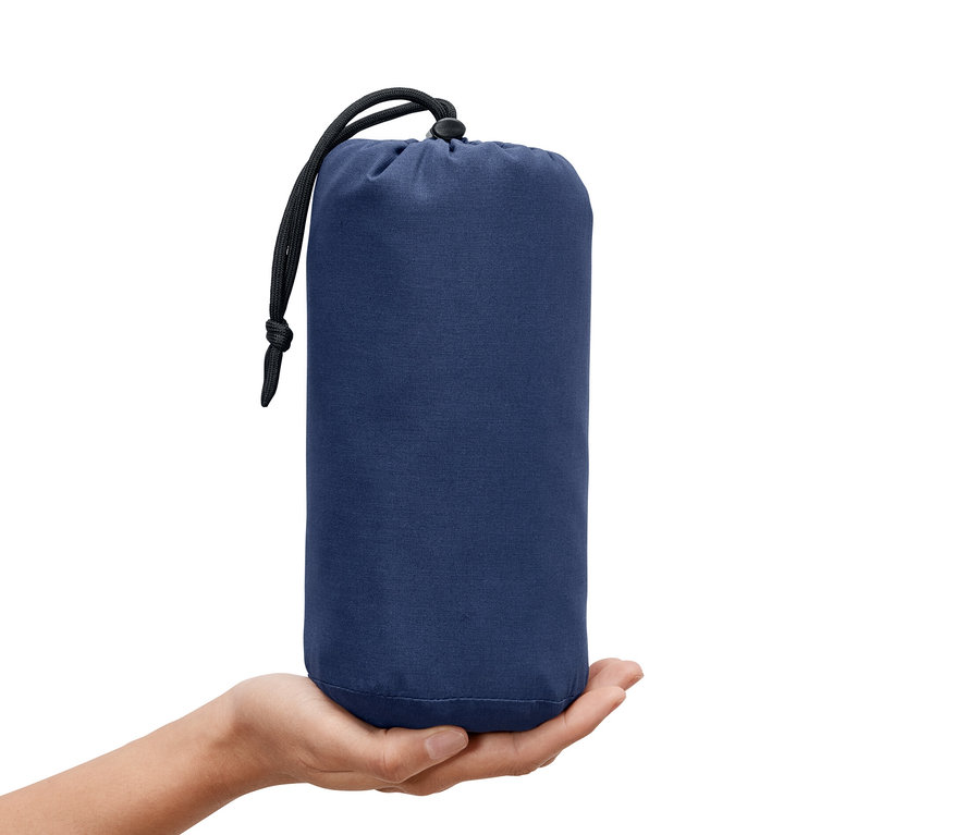 Ruka drží modrú vložku do spacieho vaku so sťahovacou šnúrkou.
