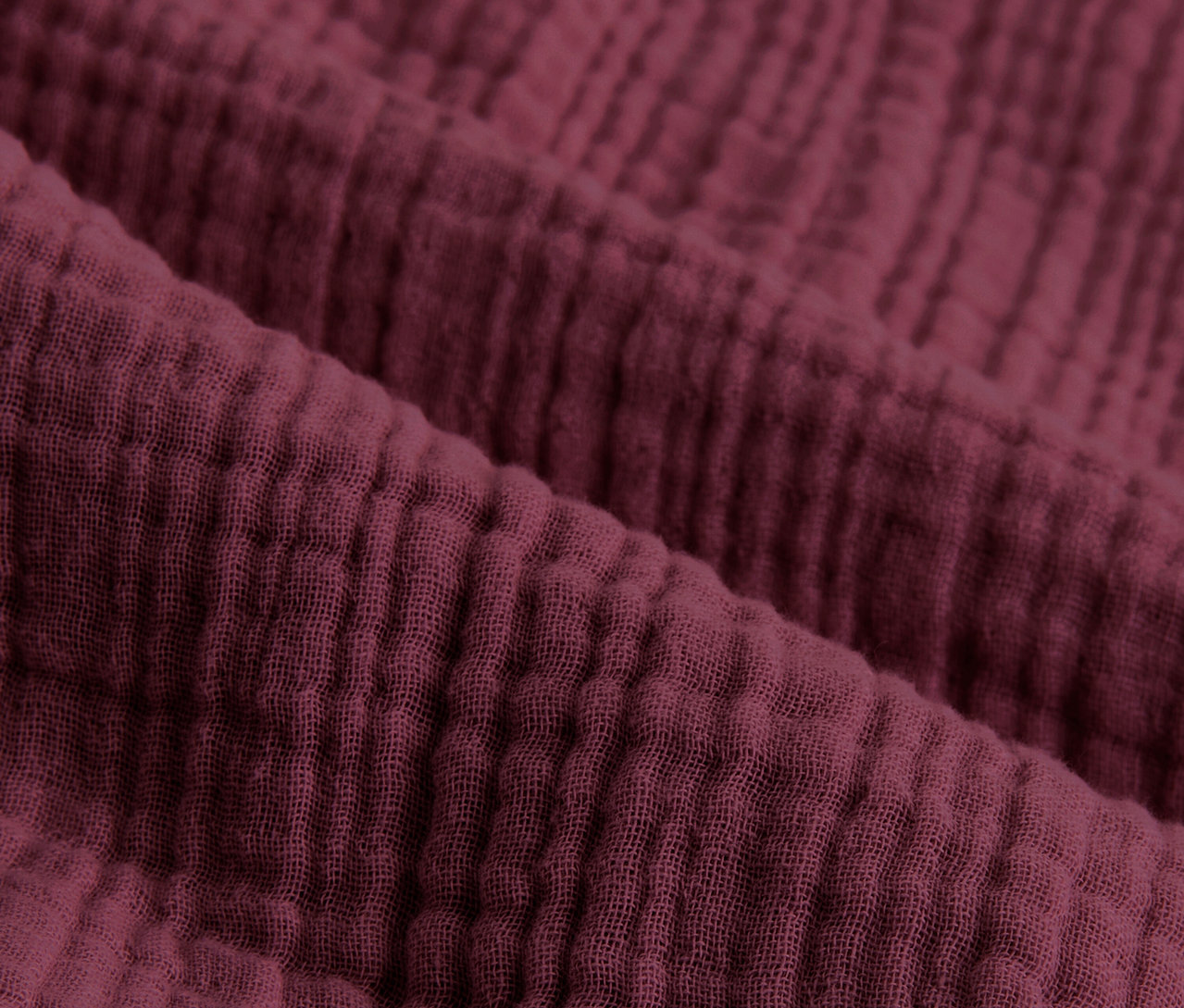Detail mušelínových obliečok vínové farby štandardnej veľkosti.