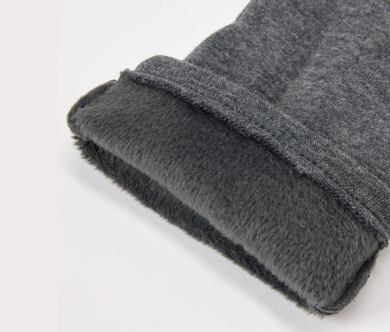 Detail šedej látky s flísovou podšívkou.