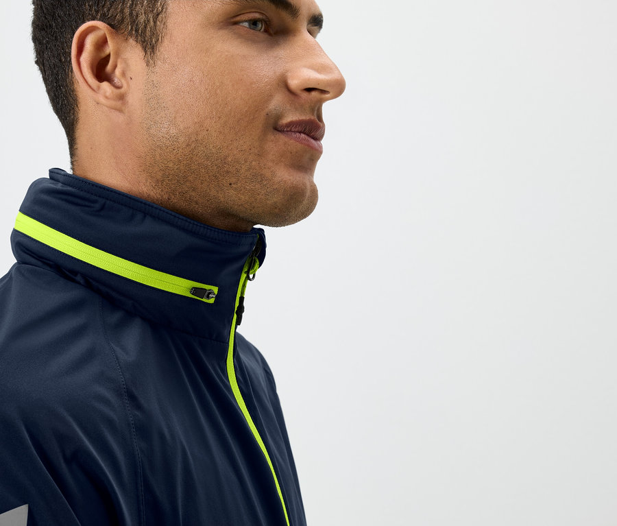 Profil muža v tmavomodrej bunde so žltými detailmi.