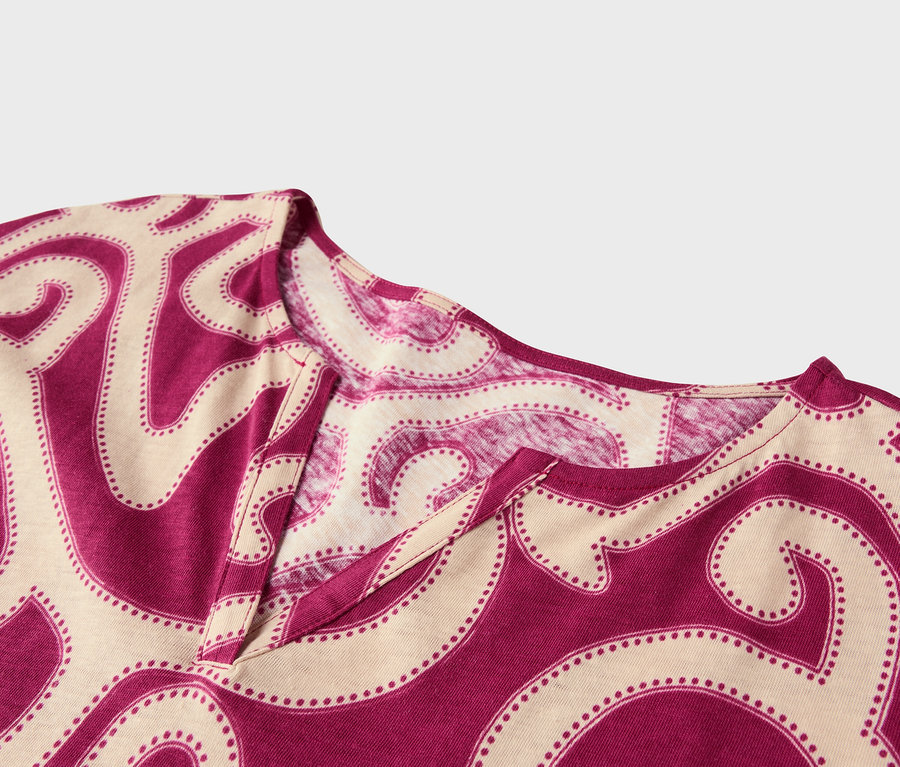 Detailný záber na top s výstrihom do V a abstraktným vzorom v purpurovej a béžovej farbe.