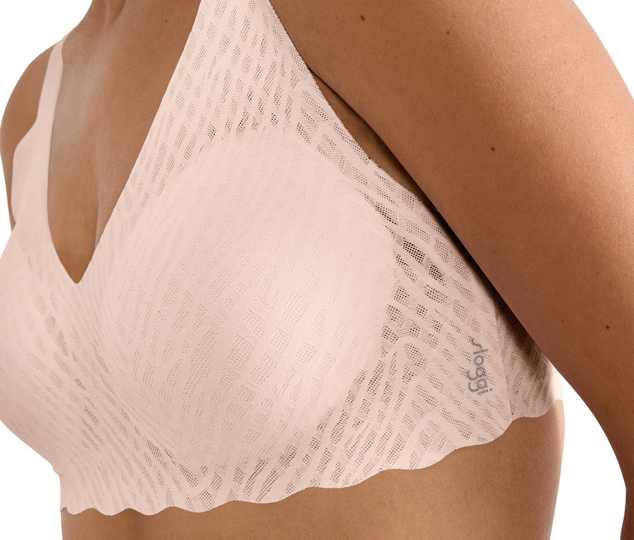 Detailný záber ženy v svetloružovej podprsenke.