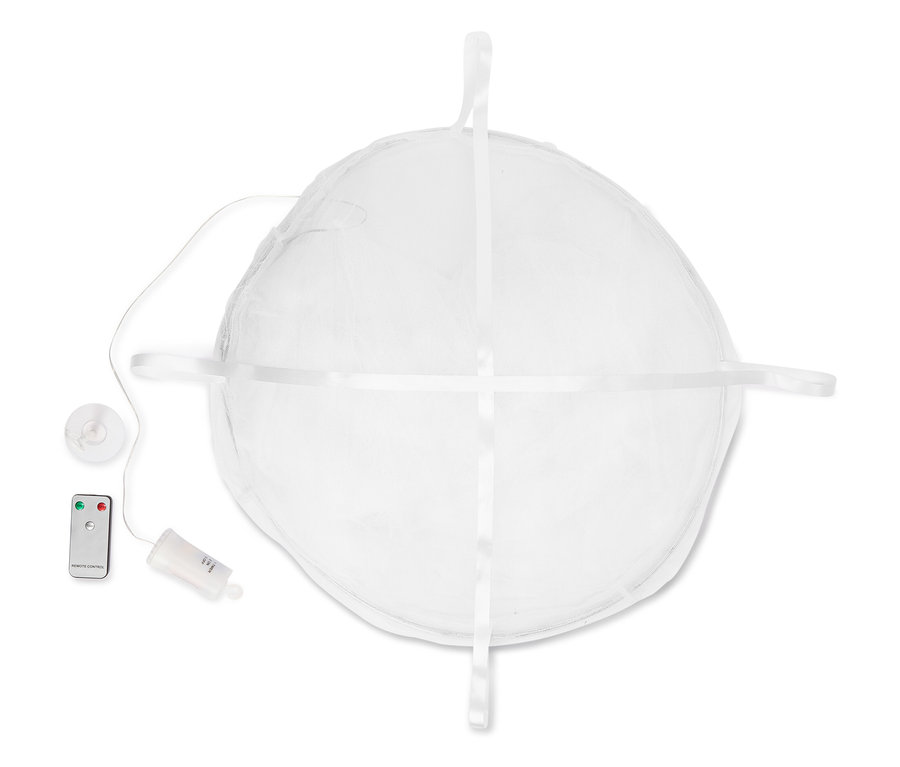 Pohľad zhora na bielu, okrúhlu papierovú lampu so stuhami, diaľkovým ovládaním a priehradkou na batérie.