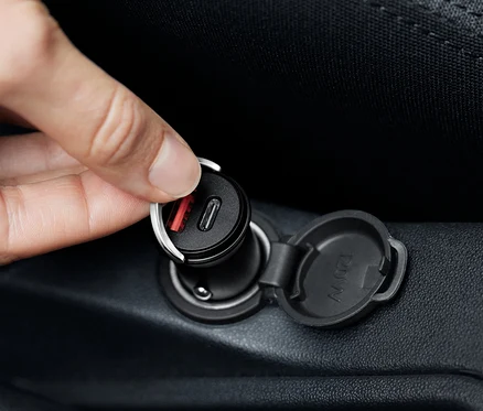 Ruka pripája čiernu nabíjačku do auta USB-C.