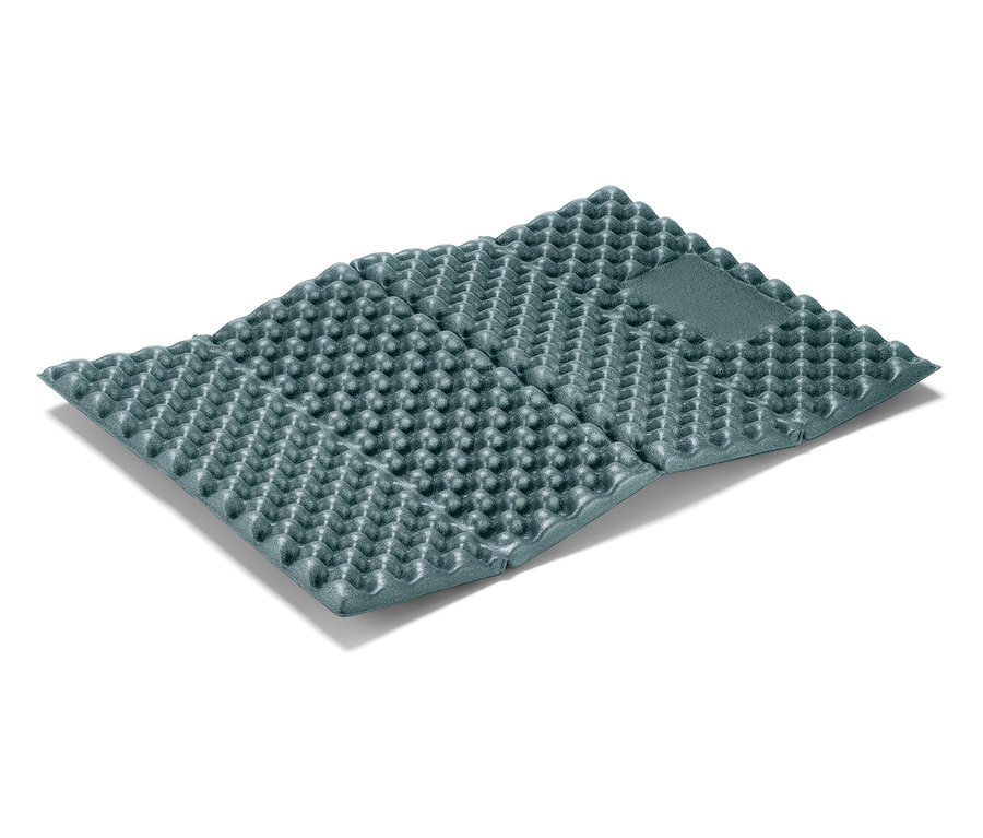 Zložená, sivá karimatka leží na bielom pozadí.