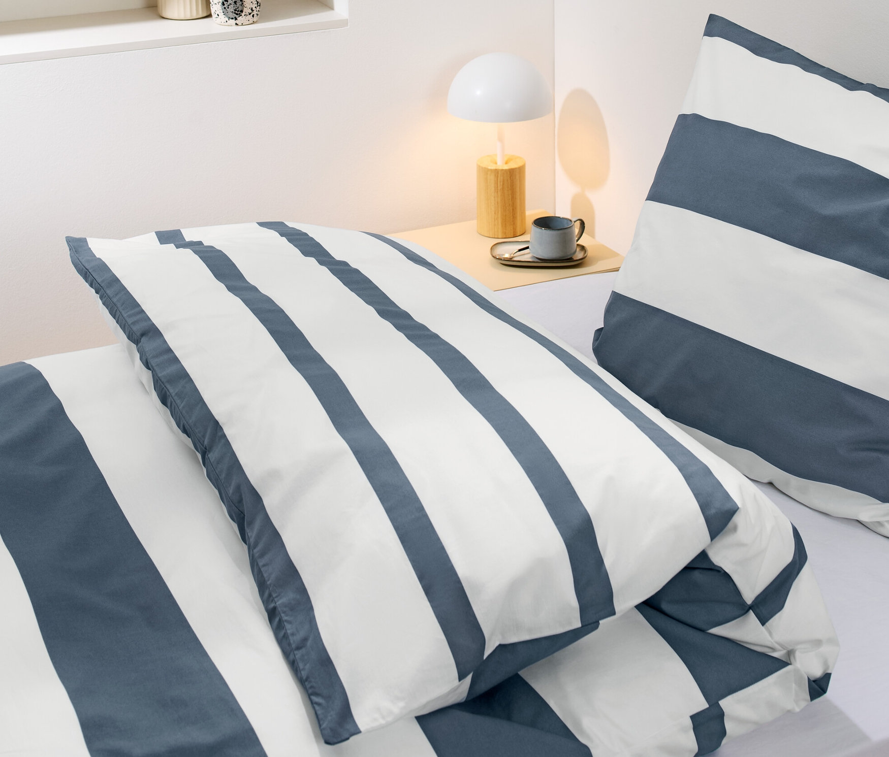 Detail posteľnej bielizne z perkálu s pásikmi štandardnej veľkosti na posteli.