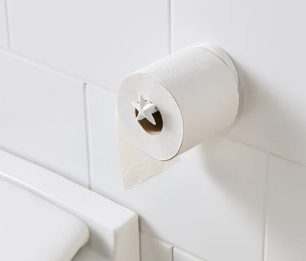 Držiak na toaletný papier s toaletným papierom na bielych dlaždiciach.
