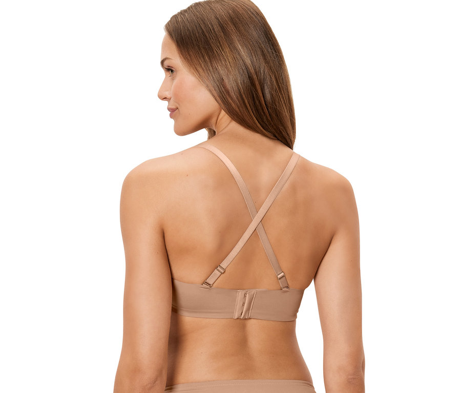 Pohľad zozadu na ženu v telovej multifunkčnej podprsenke, ktorej ramienka sú vzadu prekrížené.