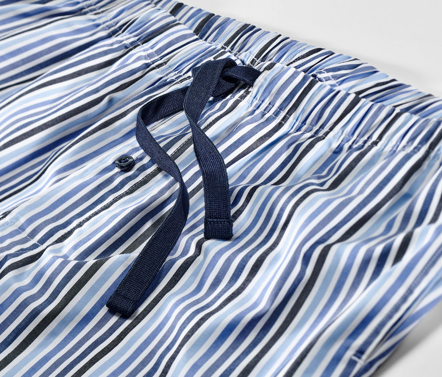 Detail krátkeho pyžama s modrými a bielymi pruhmi a sťahovacou šnúrkou.