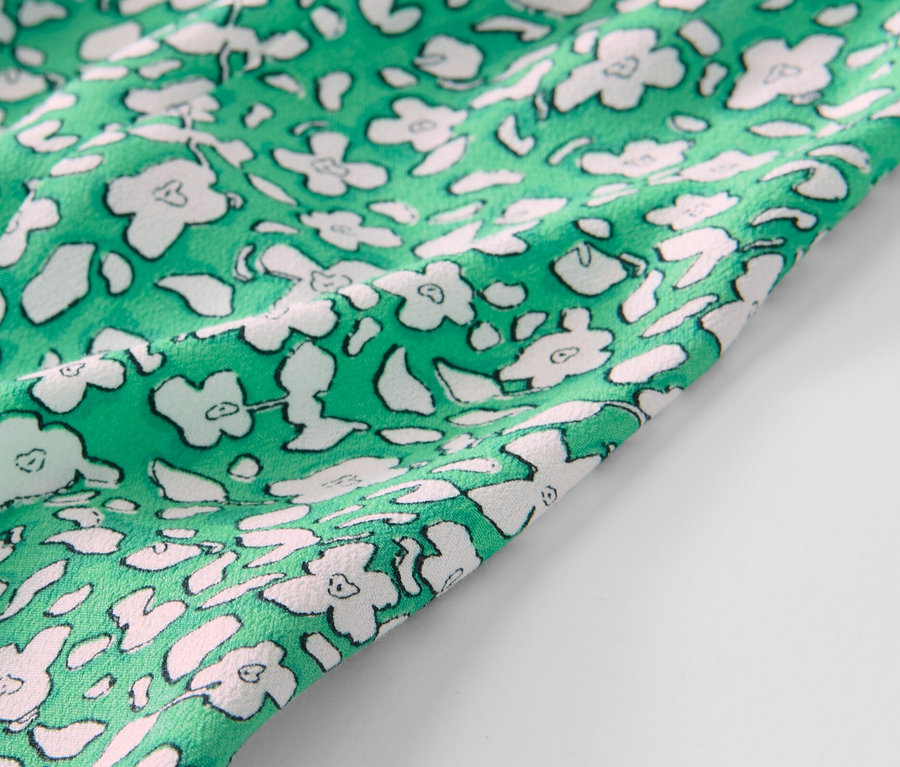 Detail zelenej midi sukne s potlačou.