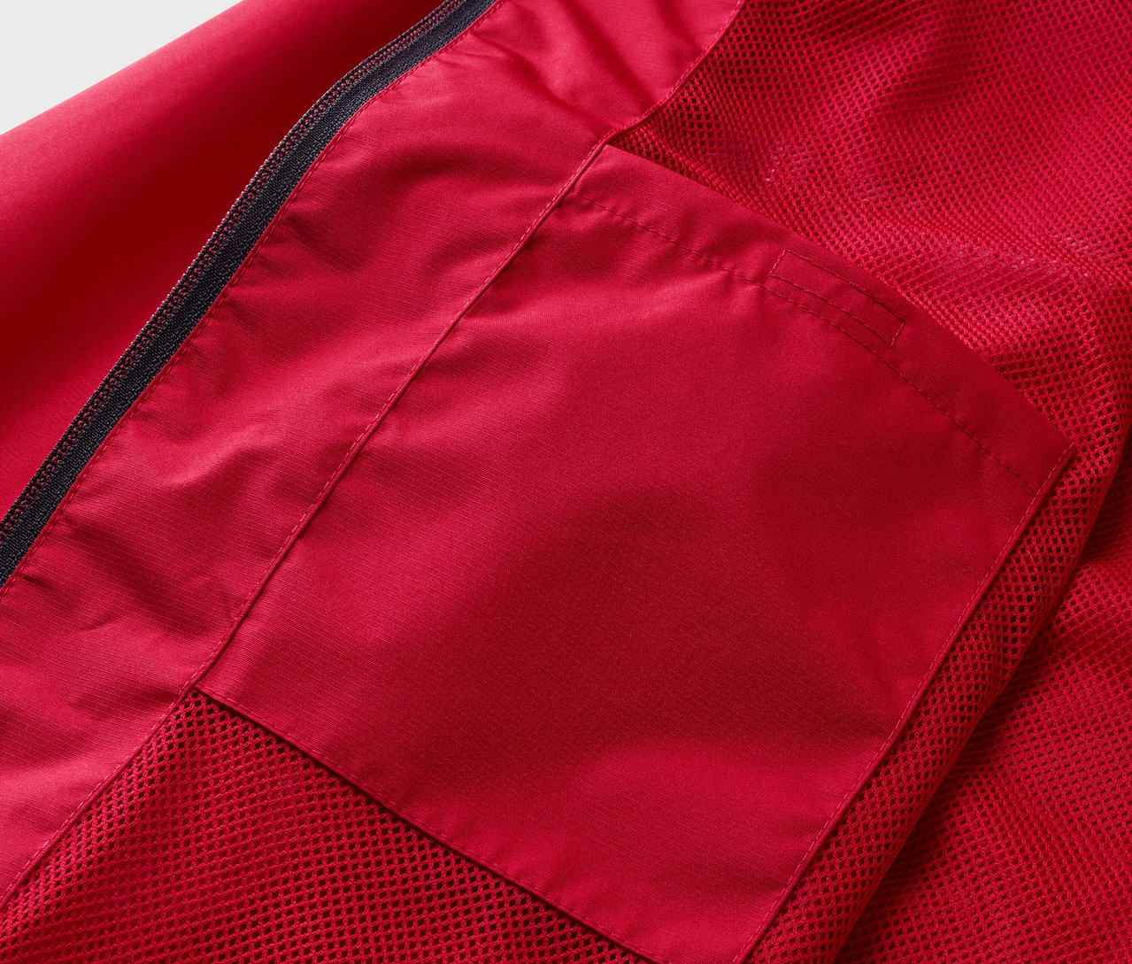 Detail červenej bundy do dažďa s vreckom.