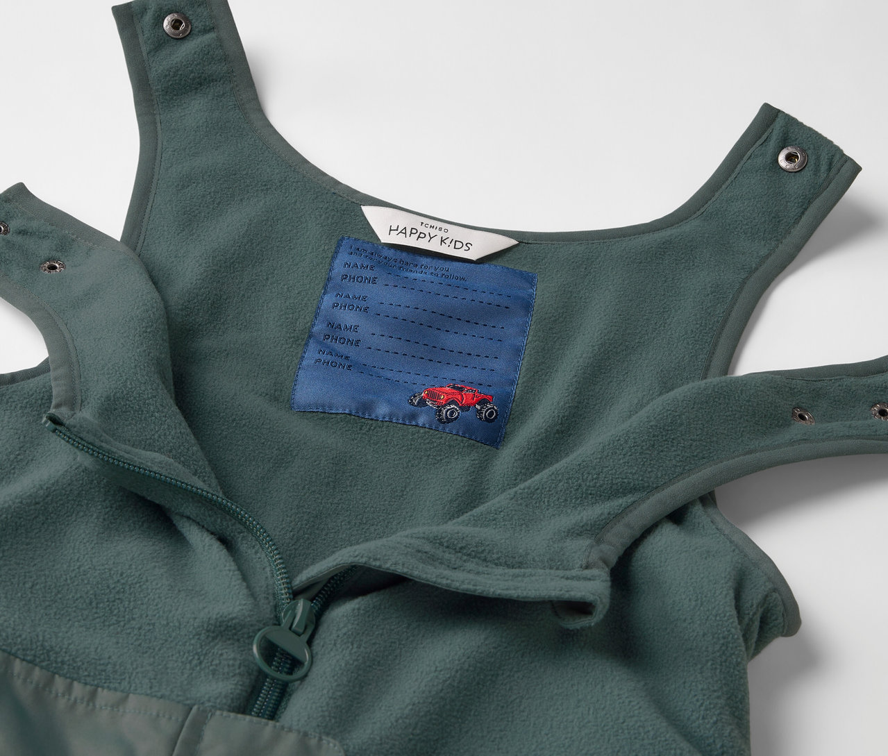 Detail detských termo nohavíc do dažďa s náprsným vreckom a červeným autom.