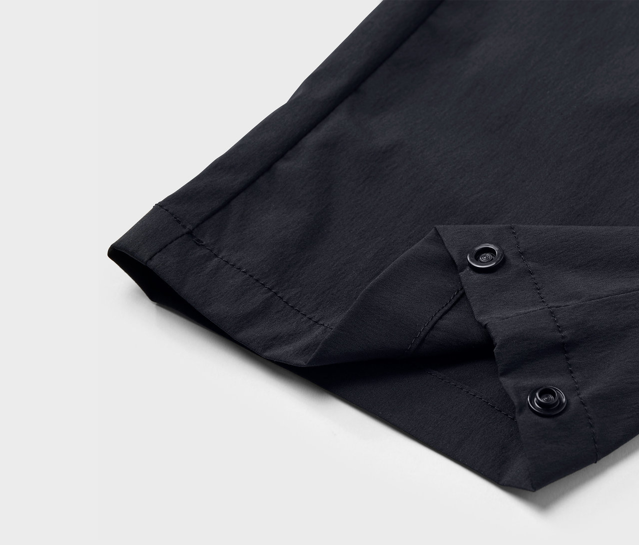 Detail čiernych funkčných nohavíc so zapínaním na patentky.