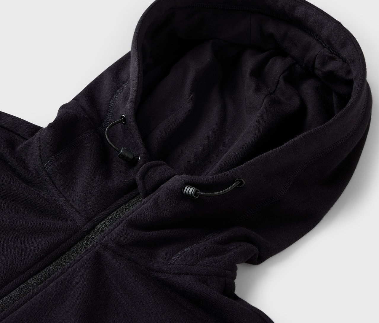 Detail čiernej mikiny s kapucňou so sťahovacou šnúrkou.
