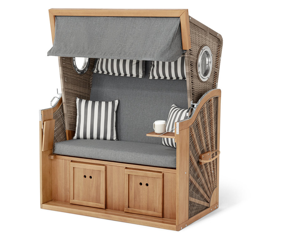 Prútený plážový kôš so sivými vankúšmi a pruhovanými akcentmi.