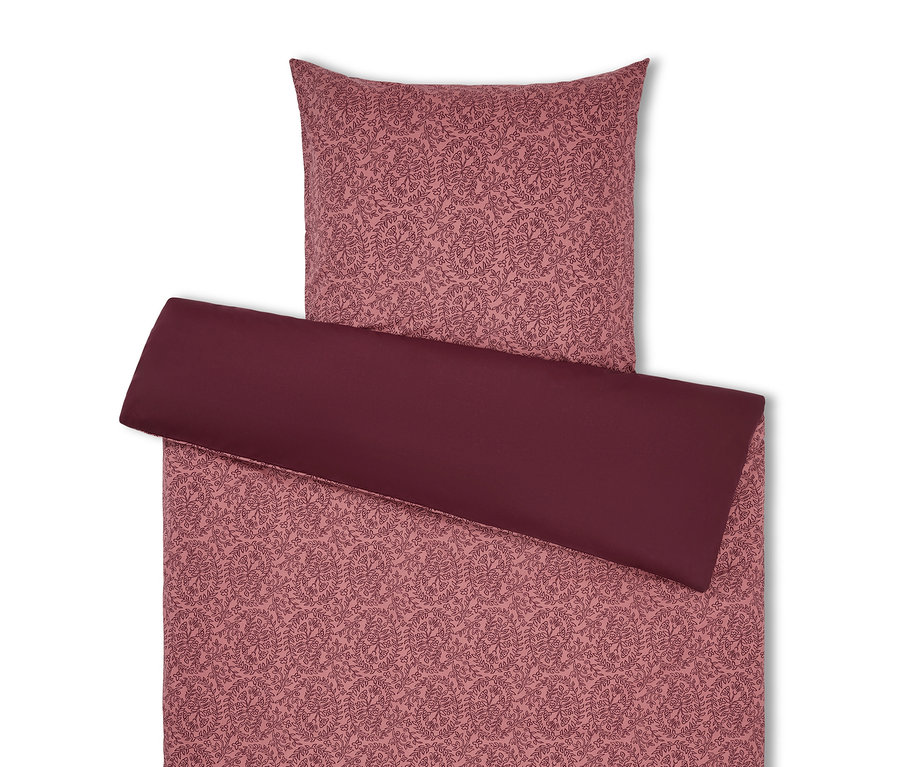 Posteľná bielizeň s kvetinovým vzorom v odtieňoch ružovej a bordovej.