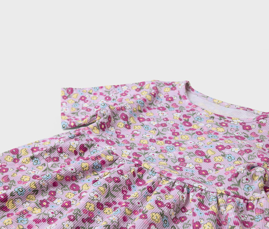 Detail fialových šiat s kvetinovou potlačou.