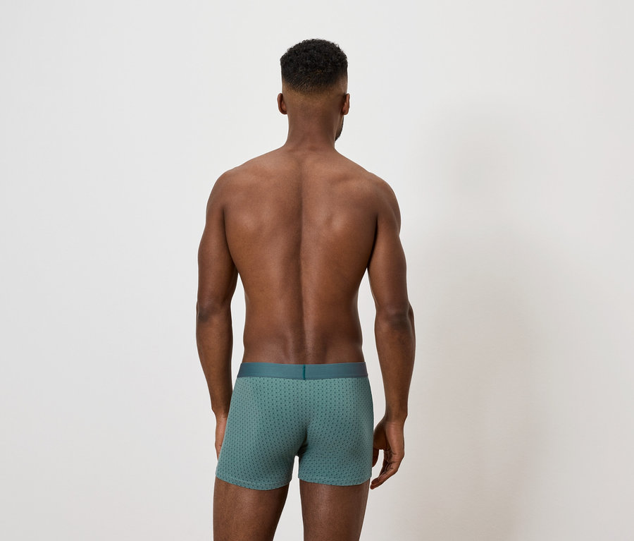 Muž chrbtom k fotoaparátu má na sebe zelené boxerky.