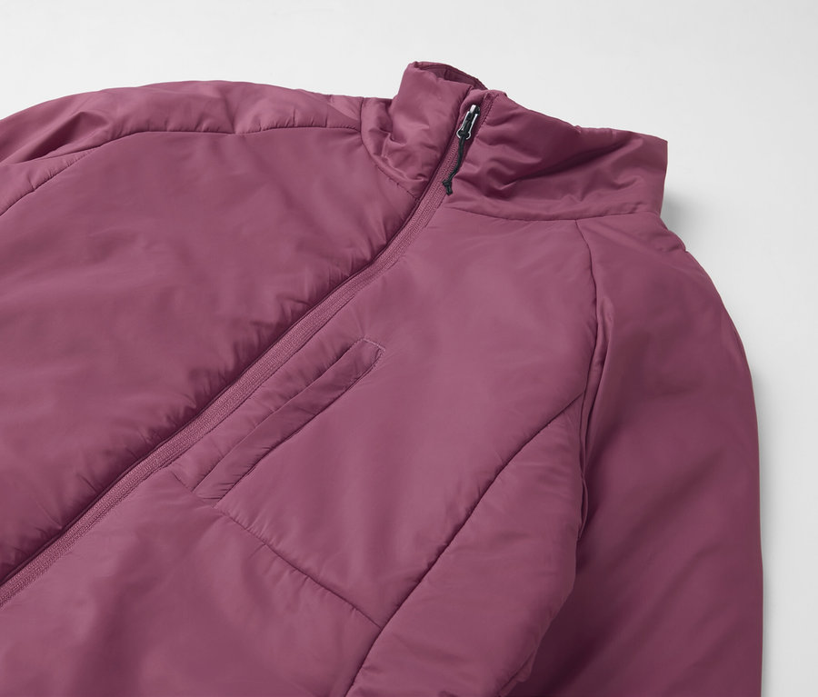 Detail fialovej bundy s krátkym zipsom a vreckom na hrudi.