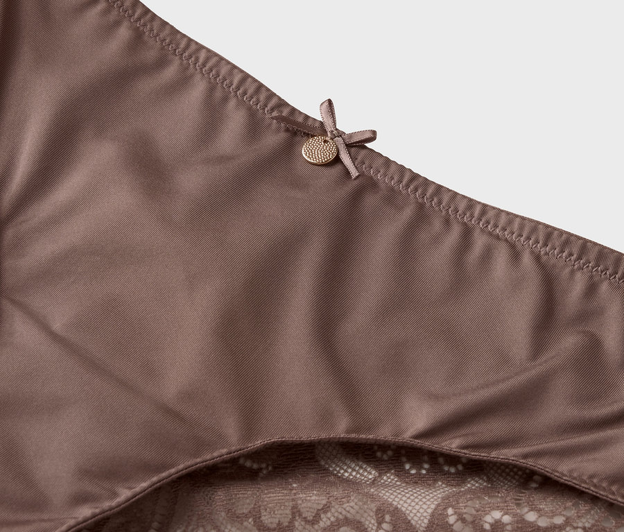 Detailný záber na hnedú spodnú bielizeň s čipkovaným lemom a mašľou.