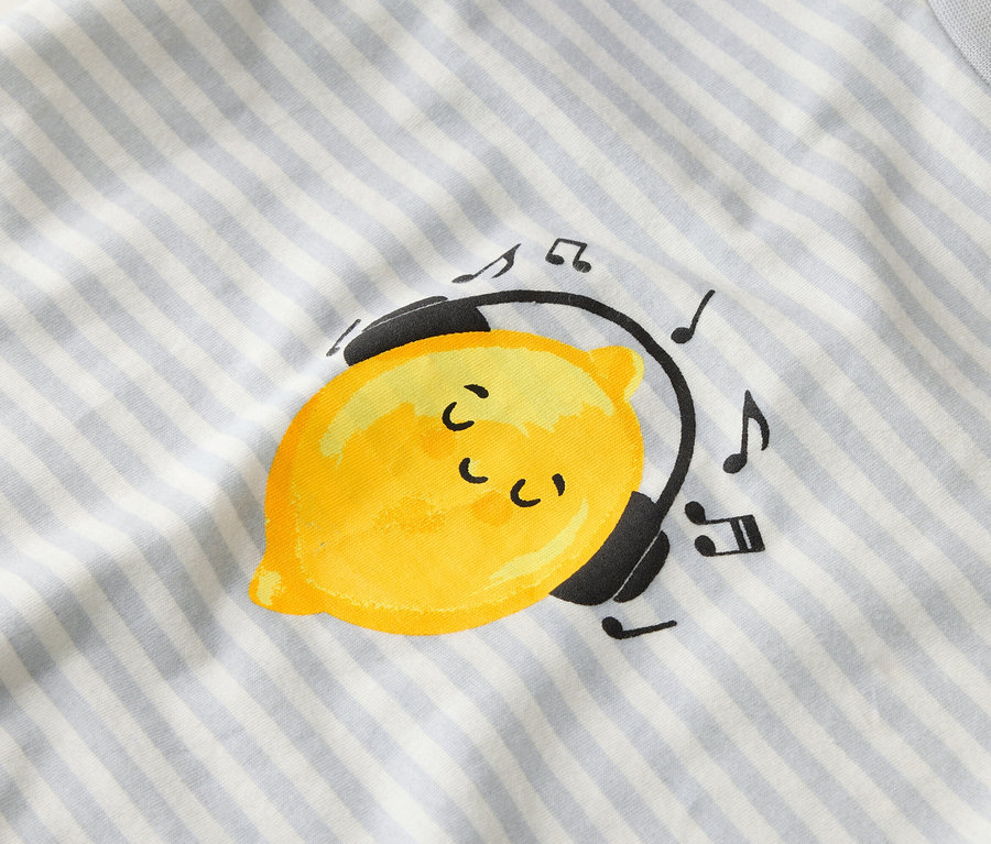 Na pruhovanej látke je zobrazený žltý citrón so slúchadlami a notami.