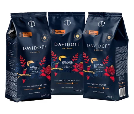 Tri balenia kávy Davidoff Origins Brazil Espresso zrnková káva, každé balenie je tmavomodré s červenými kvetmi a žltými vtákmi.