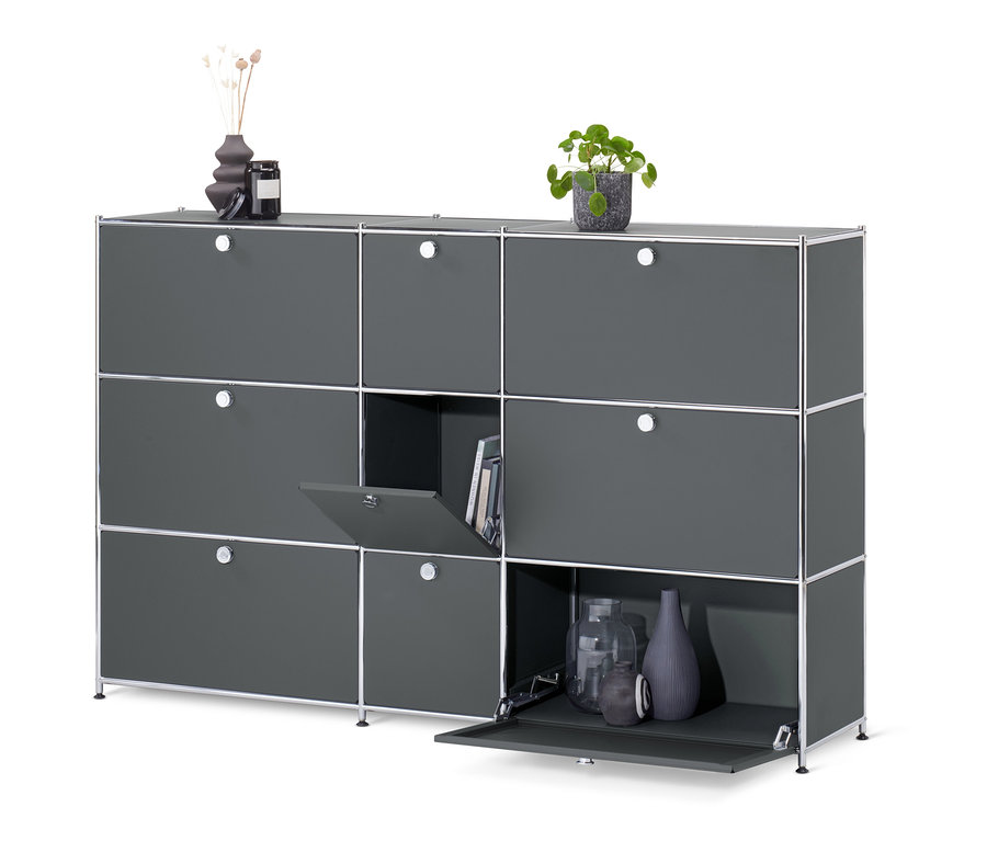 Sivá komoda »CN3« s 9 výklopnými dvierkami, z ktorých jedna je otvorená a odhaľuje knihy.