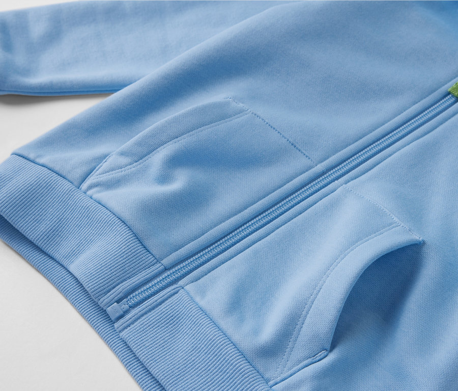 Detail modrej detskej mikiny s počesanou vnútornou stranou, zipsom a vreckami.