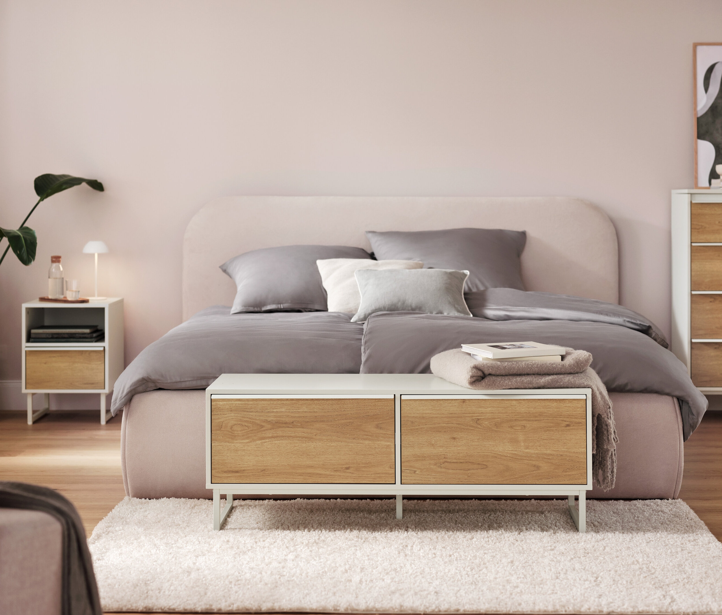 Spálňa s bielou stolovou LED lampou s akumulátorom na nočnom stolíku.