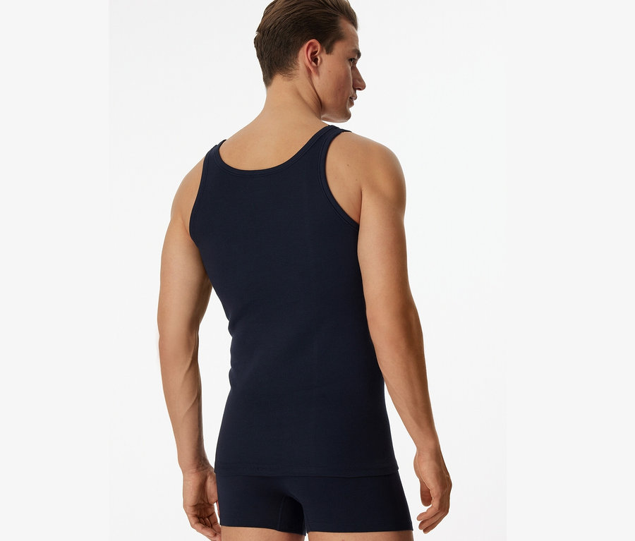 Muž zozadu má na sebe modré tielko SCHIESSER s rebrovaným úpletom, 2 ks.