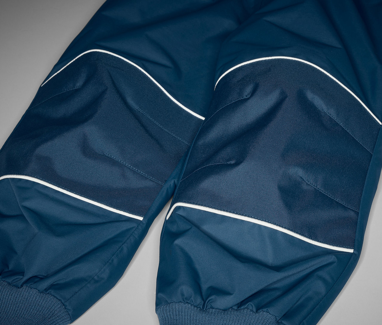 Detail detských nohavíc do dažďa, ktoré rastú s dieťatkom, s reflexnými prvkami.