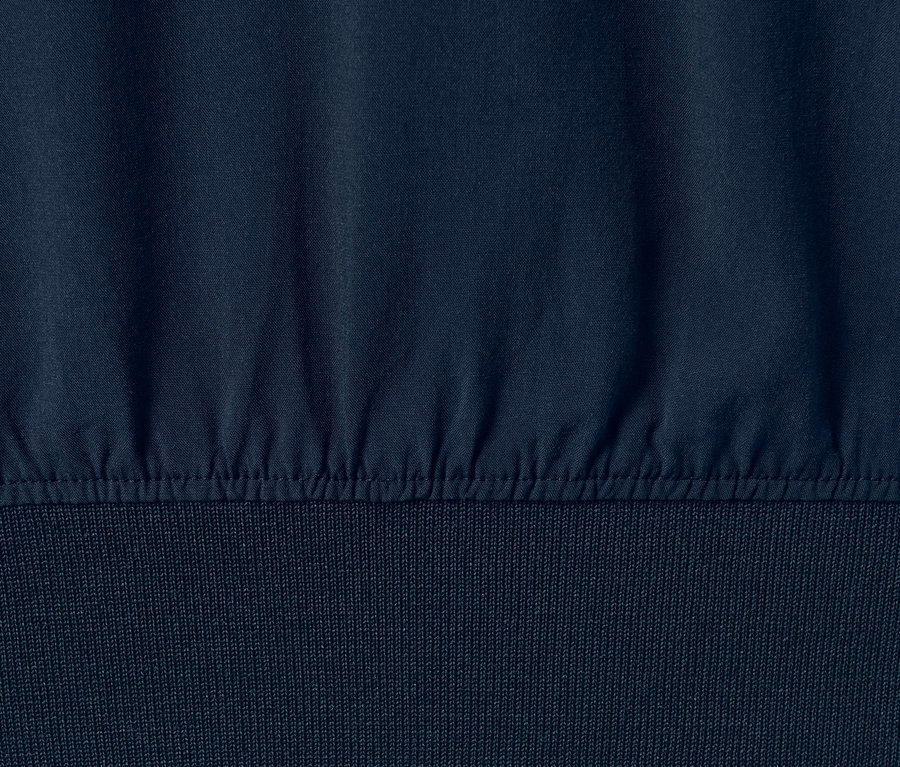Detail blúzky s rebrovanými lemami v tmavomodrej farbe.