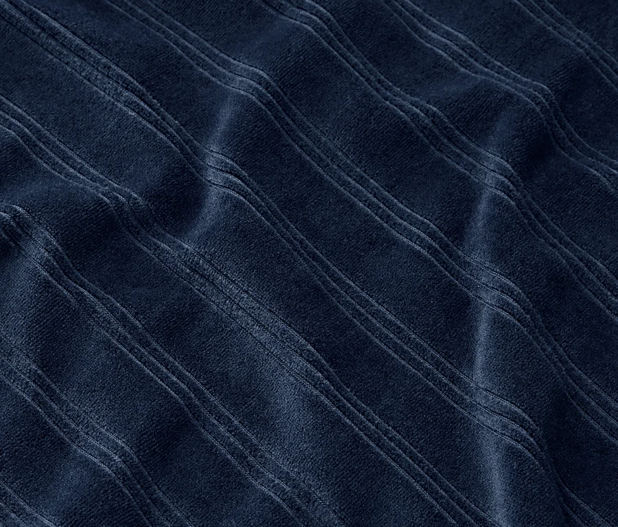Detailný záber na tmavomodrú látku s reliéfnymi pruhmi.