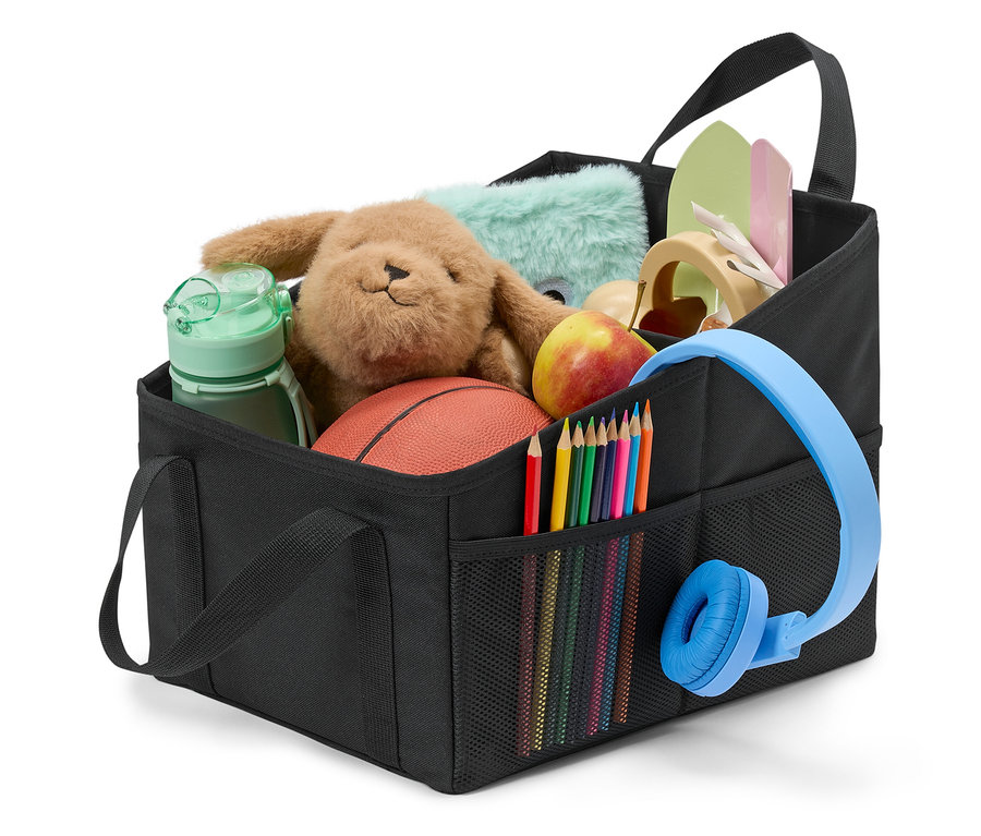 Čierny organizér naplnený hračkami, pastelkami, slúchadlami a jablkom.