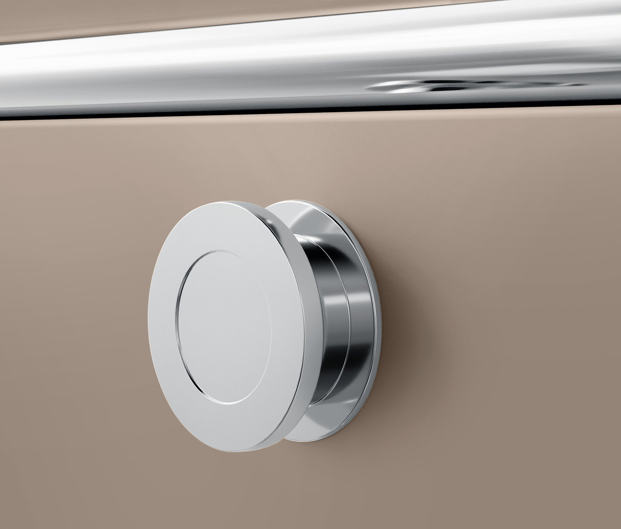 Detail chrómovej okrúhlej rukoväte na béžovom povrchu.