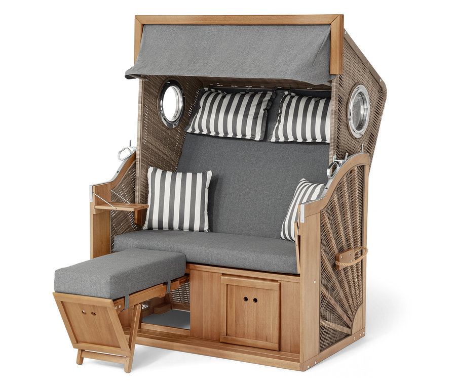 Plážový kôš z prútia a dreva so sivými vankúšmi a pruhovanými vankúšmi.