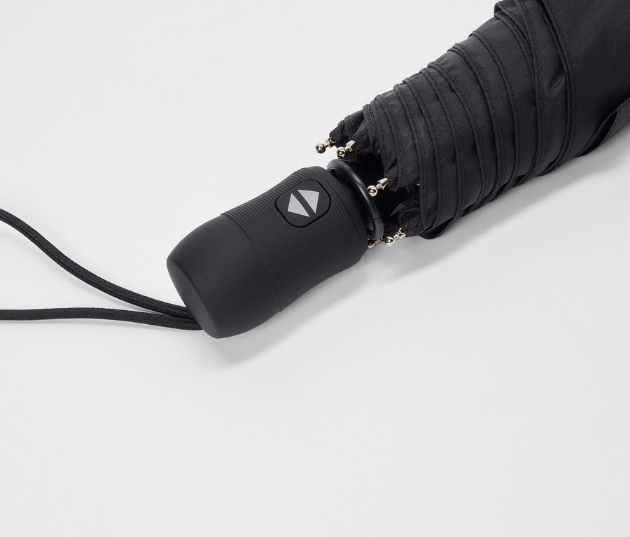 Detailný záber na zložený čierny dáždnik s rúčkou a popruhom na prenášanie na bielom pozadí.