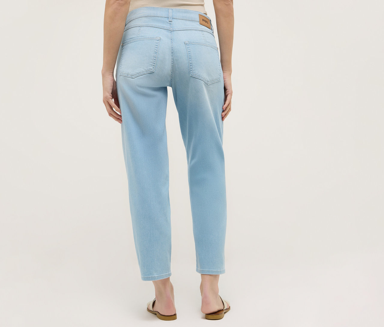 Pohľad zozadu na ženu v svetlomodrých džínsoch Angels Denim »Evy Cool« O-Shape a sandáloch.