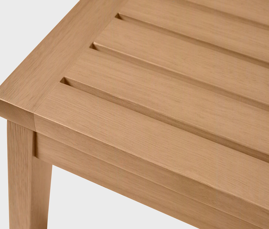 Detailný záber na svetlohnedú drevenú lavicu s lamelovým roštom