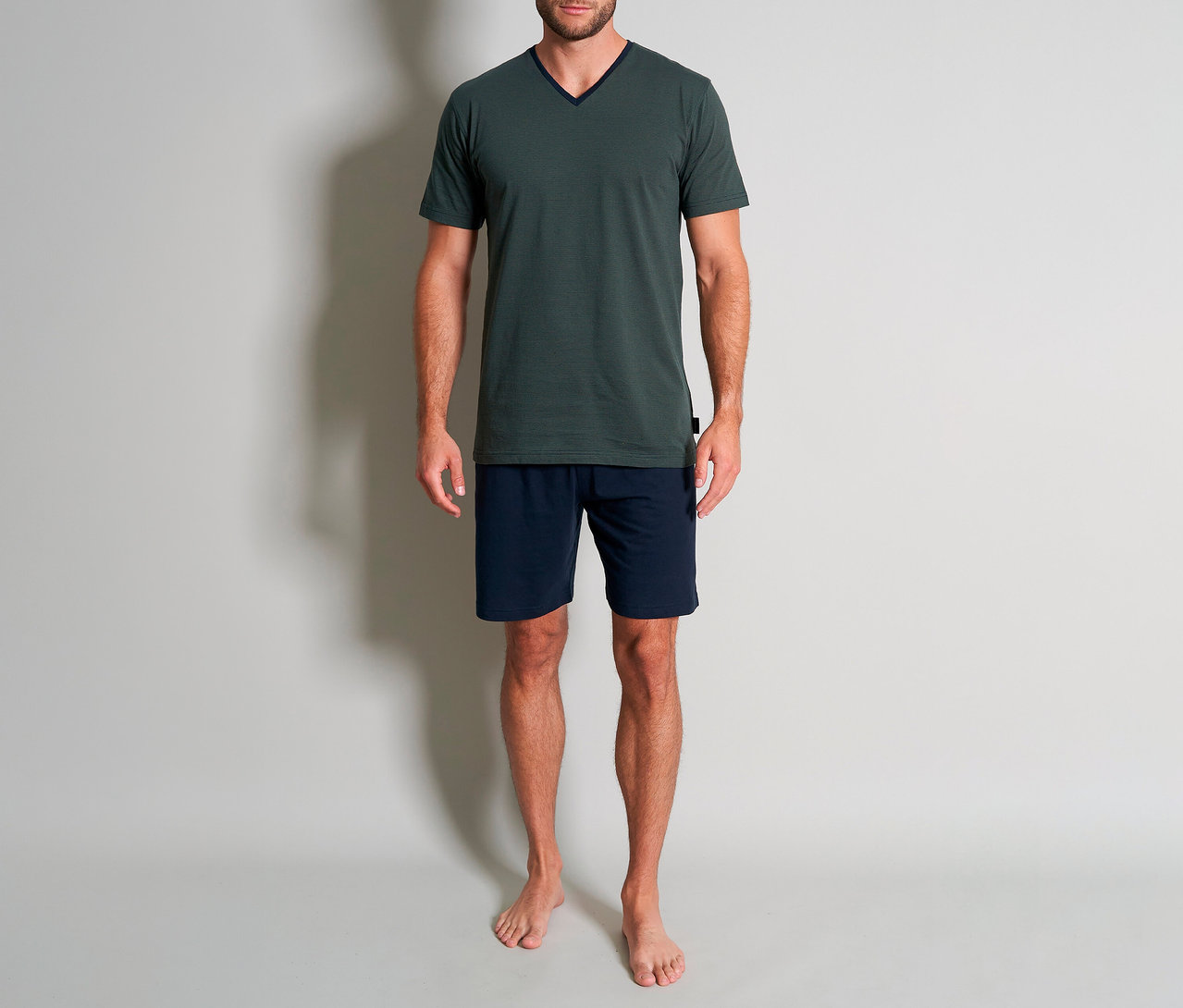 Muž v zelenom krátkom pyžamovom sete Tom Tailor »Nevada«, ktorý pozostáva z trička a krátkych, modrých nohavíc.