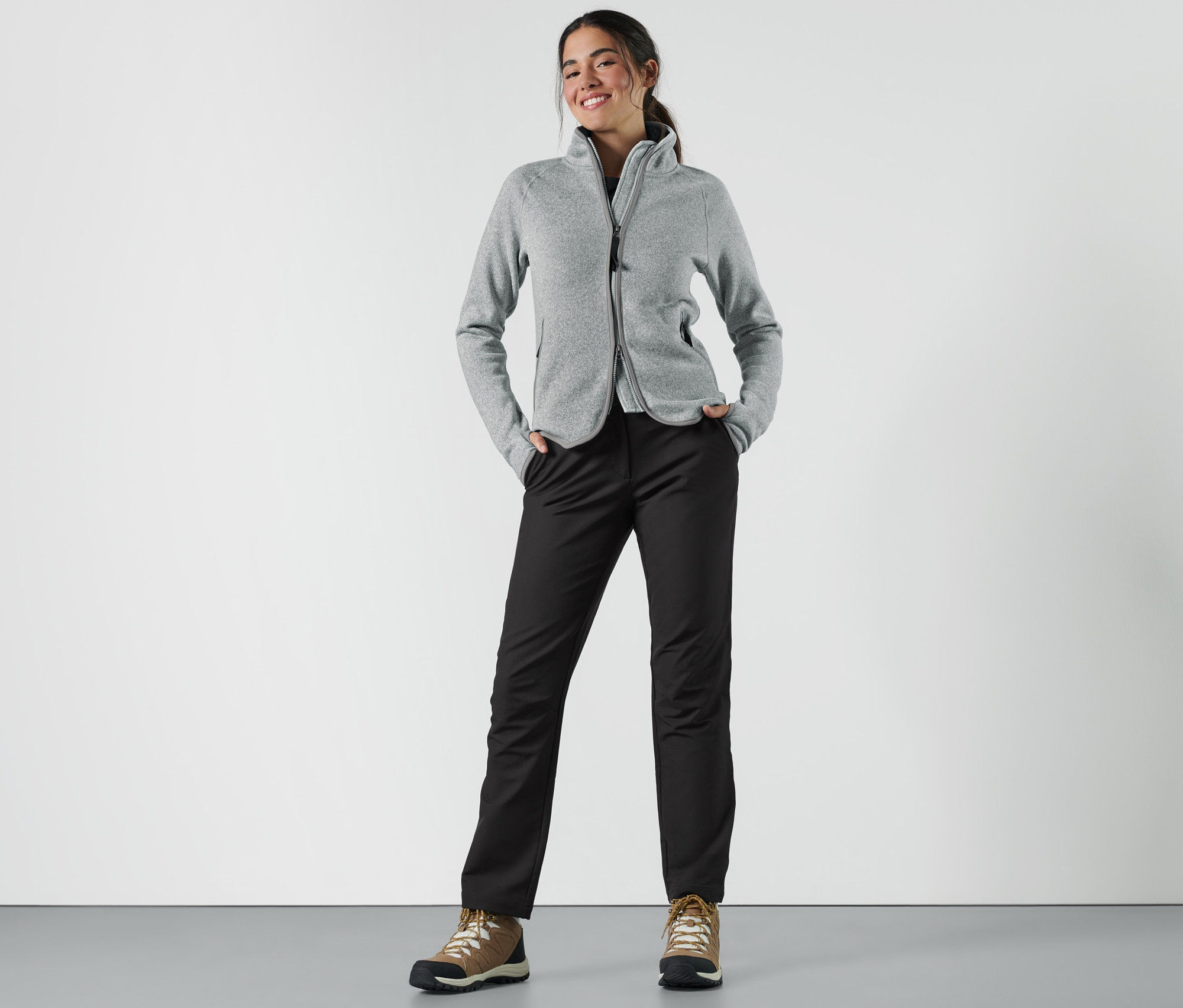 Žena stojí a má ruky vo vreckách softshellových nohavíc.