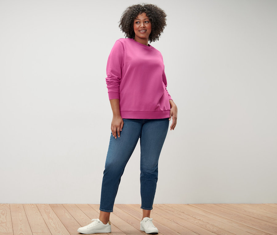 Žena pózuje v ružovej mikine a tregínsoch »Fit Nelly«.