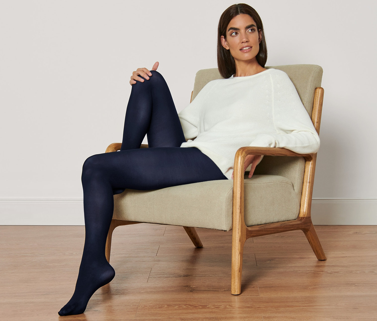 Žena sedí v kresle a má na sebe jemné pančuchové nohavice, 2 ks.