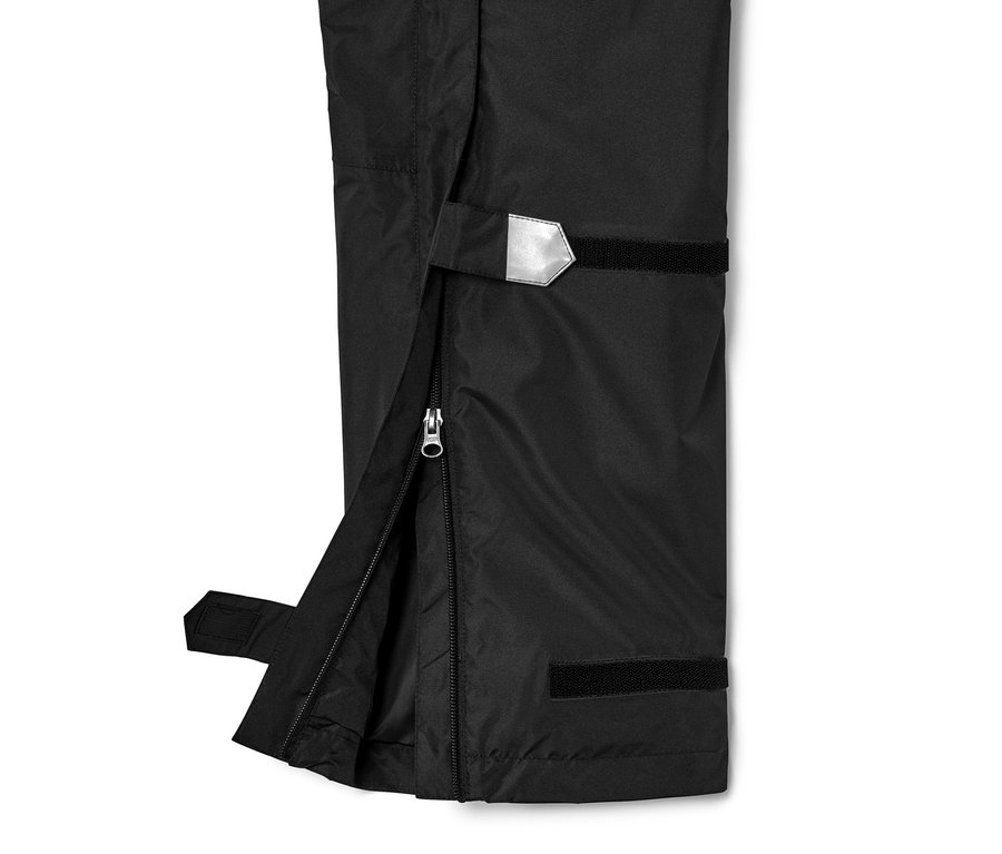 Detailný záber na čierne high-tech nohavice do dažďa, unisex, s rozopnutým zipsom na boku.