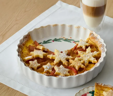 Koláč vo forme na koláče a tortičky s hviezdami z cesta a pohár latté.
