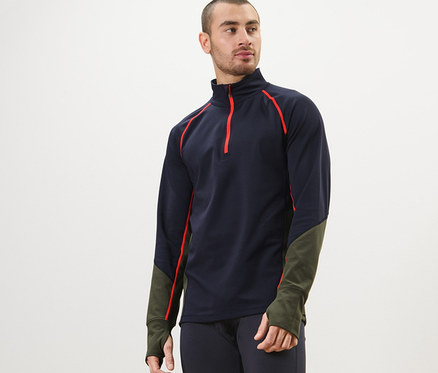 Muž má na sebe funkčné termotričko, tmavomodré legíny a pózuje.